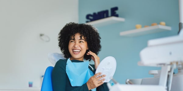 Person smiling in a dental chair.
