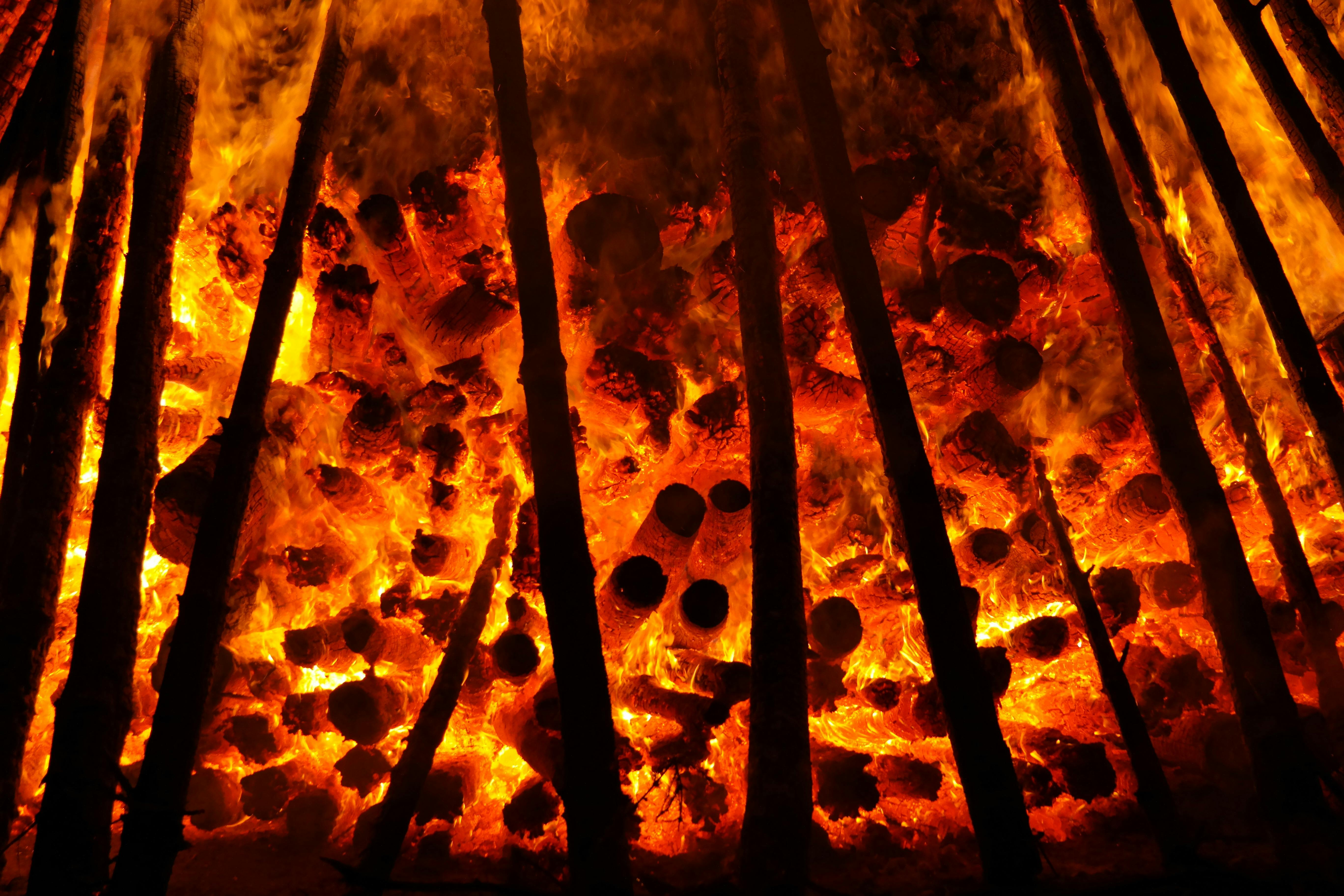 Close-up of a bonfire with intense flames and burning logs, creating a fiery spectacle.