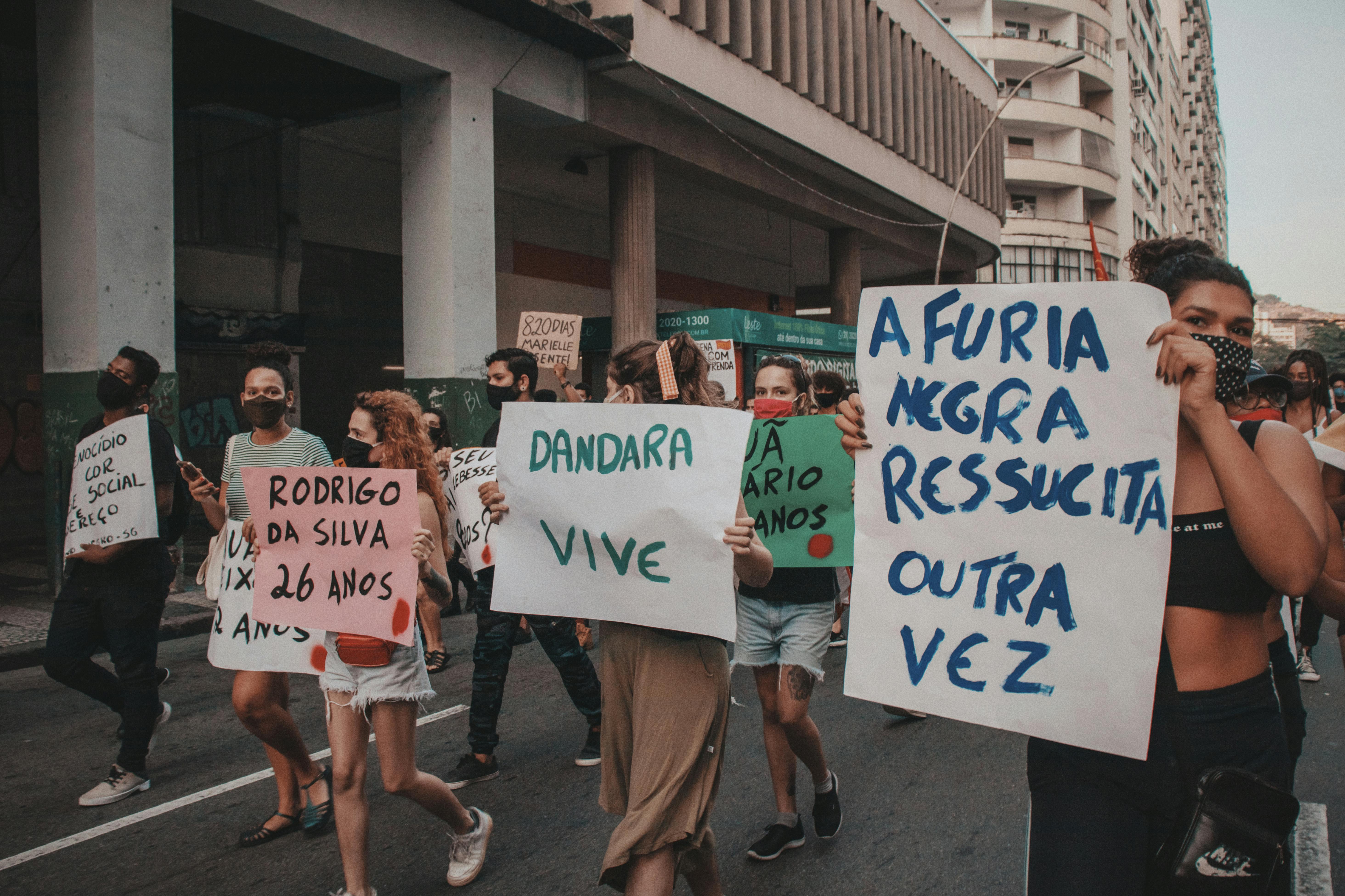 Peaceful protest in Rio de Janeiro highlighting indigenous rights. Demonstrator holding a sign.