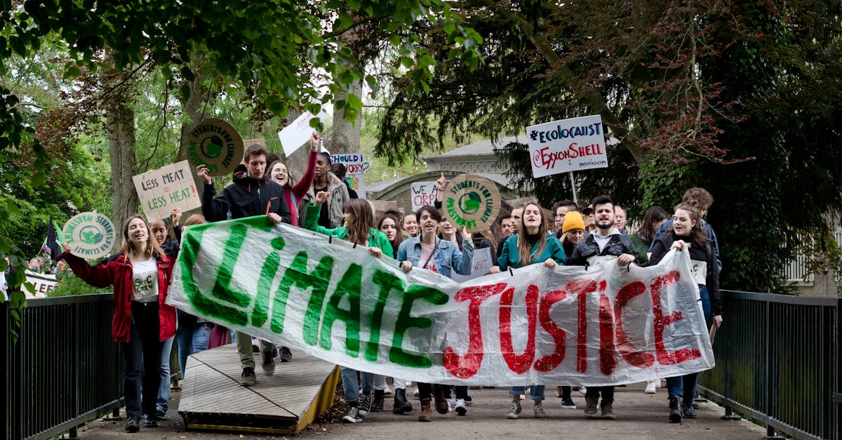 Group of activists marching for climate justice in Maastricht with banners and signs.