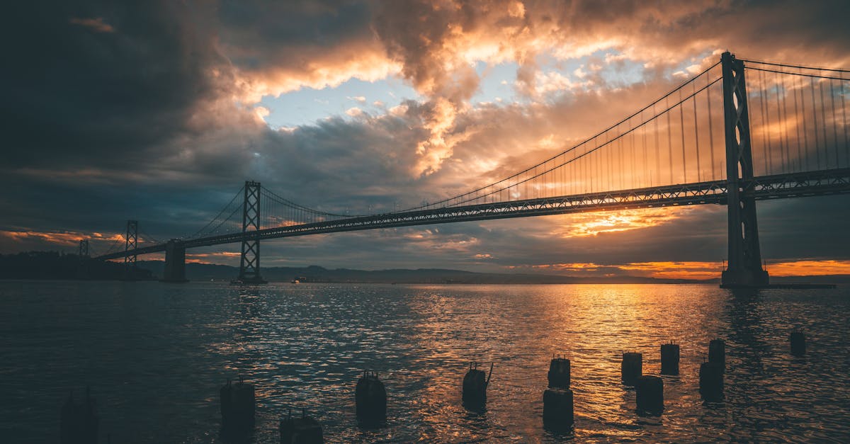 Stunning sunset view of the Bay Bridge in San Francisco reflecting on water.