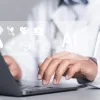 Clinician uses AI tools on a laptop to support care and documentation.&nbsp;