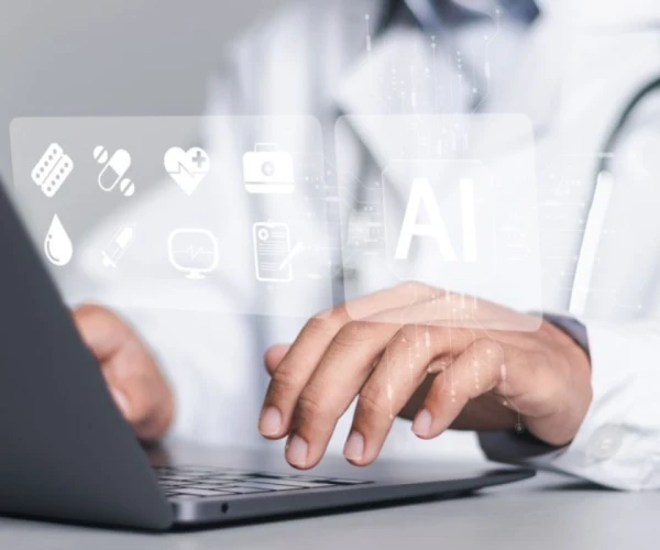 Clinician uses AI tools on a laptop to support care and documentation.&nbsp;