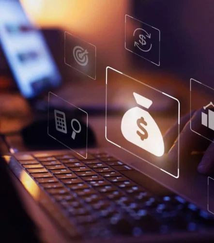 Close-up of a person working on a laptop with digital finance and analytics icons symbolizing financial planning, investment&nbsp;analysis&nbsp;and business growth.&nbsp;