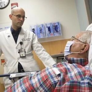 Ephraim Tsalik, MD, PhD, at Duke Health assesses a patient for respiratory symptoms. 