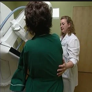Woman with radiologic technologist during screening mammography exam.