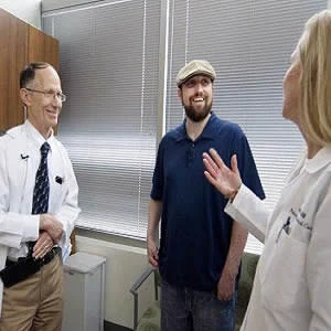 Richard Hotchkiss, MD, a professor of anesthesiology (left), and Jane Blood (right), a nurse manager in the Department of Anesthesiology&#039;s Division of Clinical and Translational Research, talk with Greg Porter, 34, of Nashville, Ill., who has recovered fr