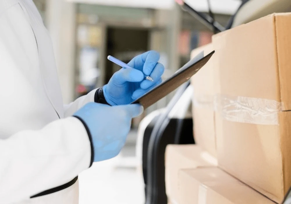 Healthcare worker in gloves checking medical supply deliveries with a clipboard&nbsp;