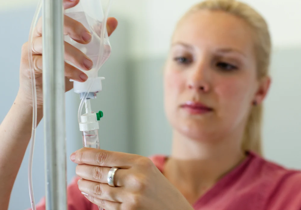  Healthcare professional adjusting IV drip, representing clinical precision, patient care, and hospital treatment procedures.