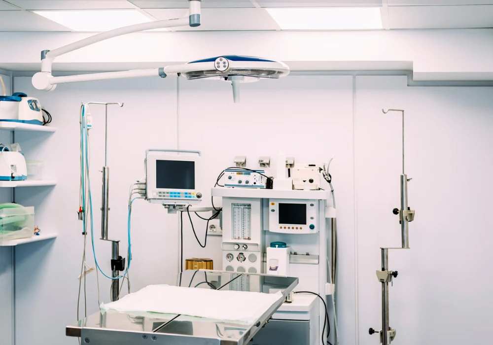 Modern operating room with advanced medical equipment, including monitors and surgical tools, representing sterile environment and readiness for surgery or emergency care.