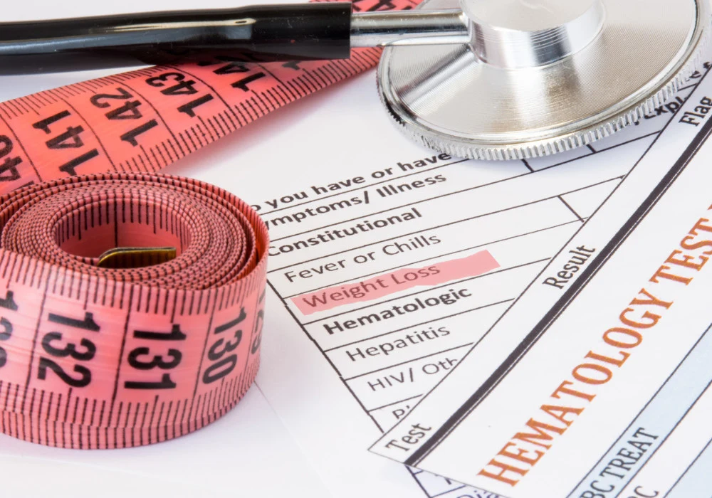 Medical tools and hematology test forms highlighting weight loss as a symptom in clinical evaluation&nbsp;