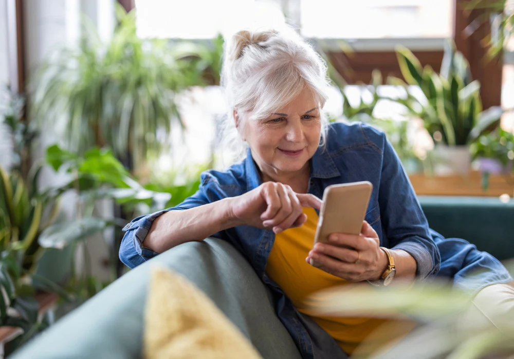 Smiling senior woman using smartphone for digital health or online communication at home&nbsp;