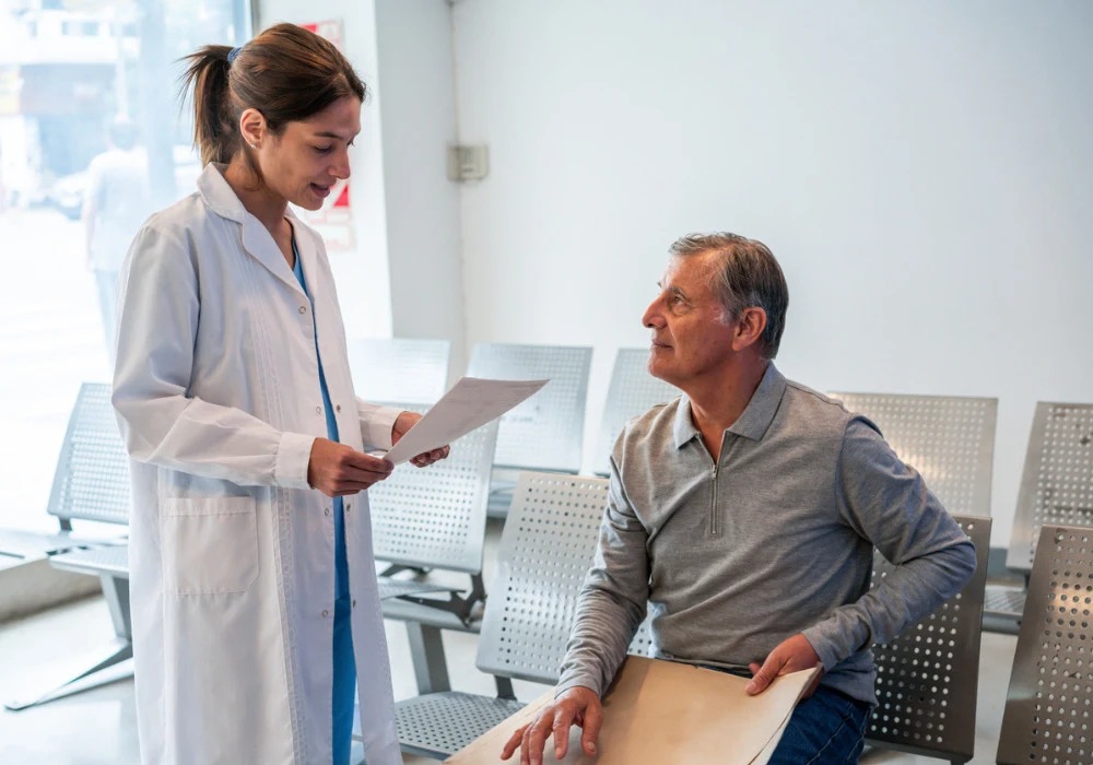 Doctor discussing medical test results with senior patient in hospital waiting area&nbsp;