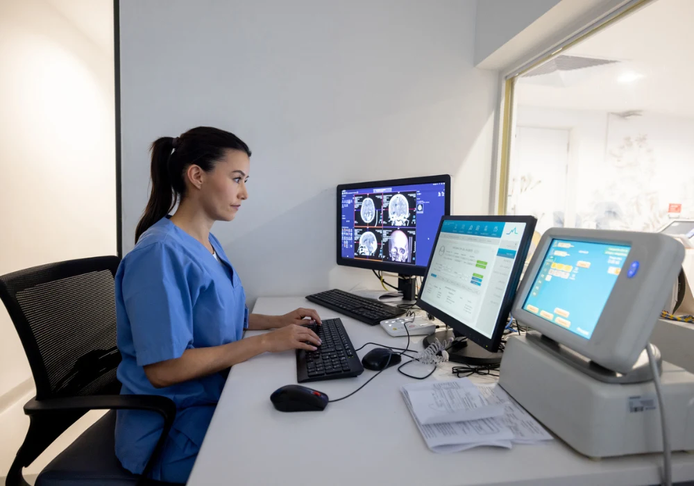 Radiology technician analysing brain scans on computer monitors in MRI control room, highlighting diagnostic imaging, neurology and healthcare technology.&nbsp;