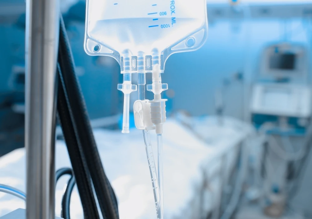 Close-up of IV drip in hospital intensive care unit with blurred patient bed in background&nbsp;