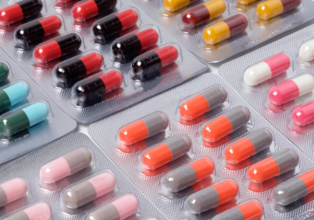 Blister packs of multicoloured capsules arranged in rows, showing various medications.&nbsp;