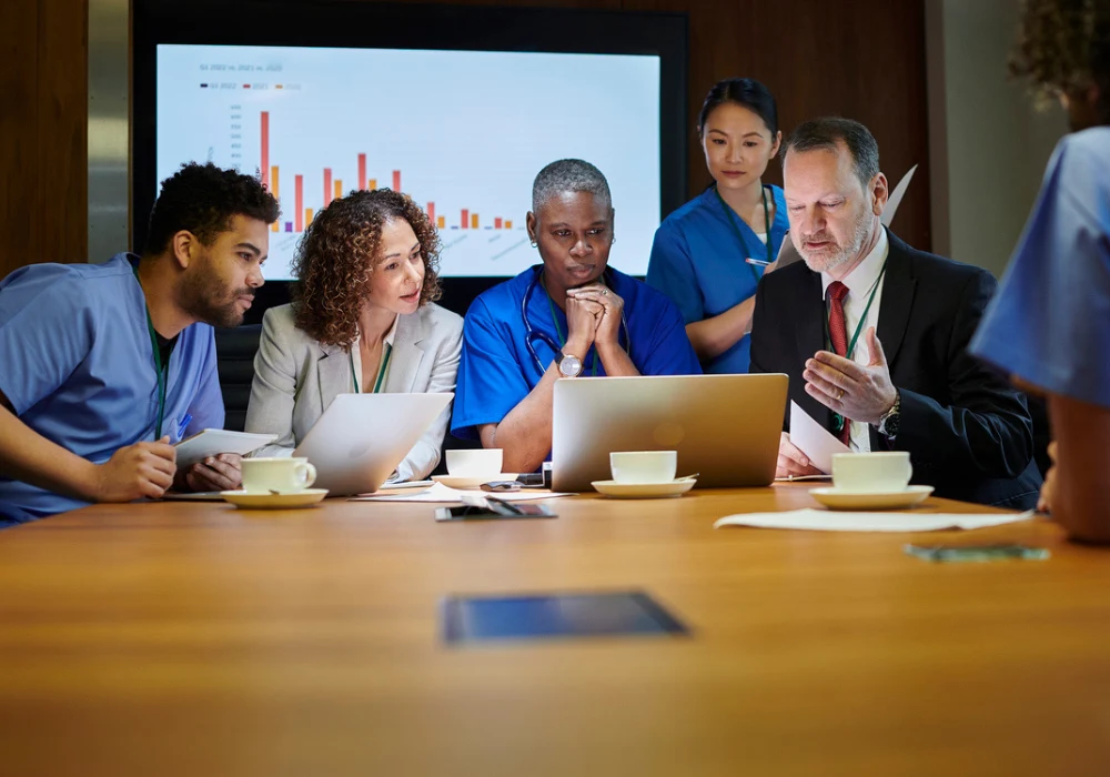 NHS clinicians and managers review dashboards to plan AI-enabled procurement and sustainable care.&nbsp;