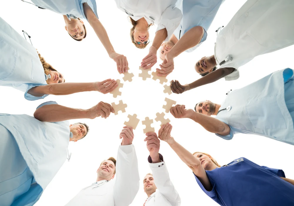 Healthcare team joining jigsaw pieces, symbolising hospital collaboration and sustainability strategy.&nbsp;