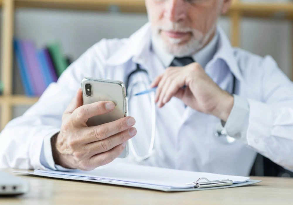 Doctor using secure smartphone messaging for telehealth follow-up and patient communication.&nbsp;