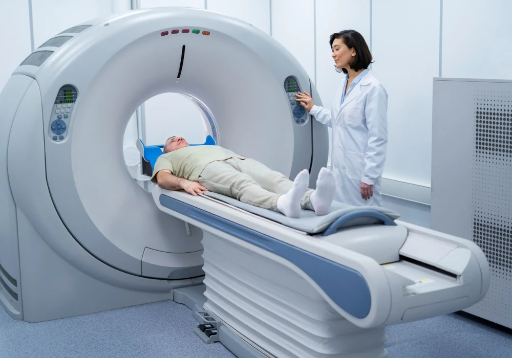 Patient undergoing CT scan with a radiology technologist in a hospital imaging suite.&nbsp;
