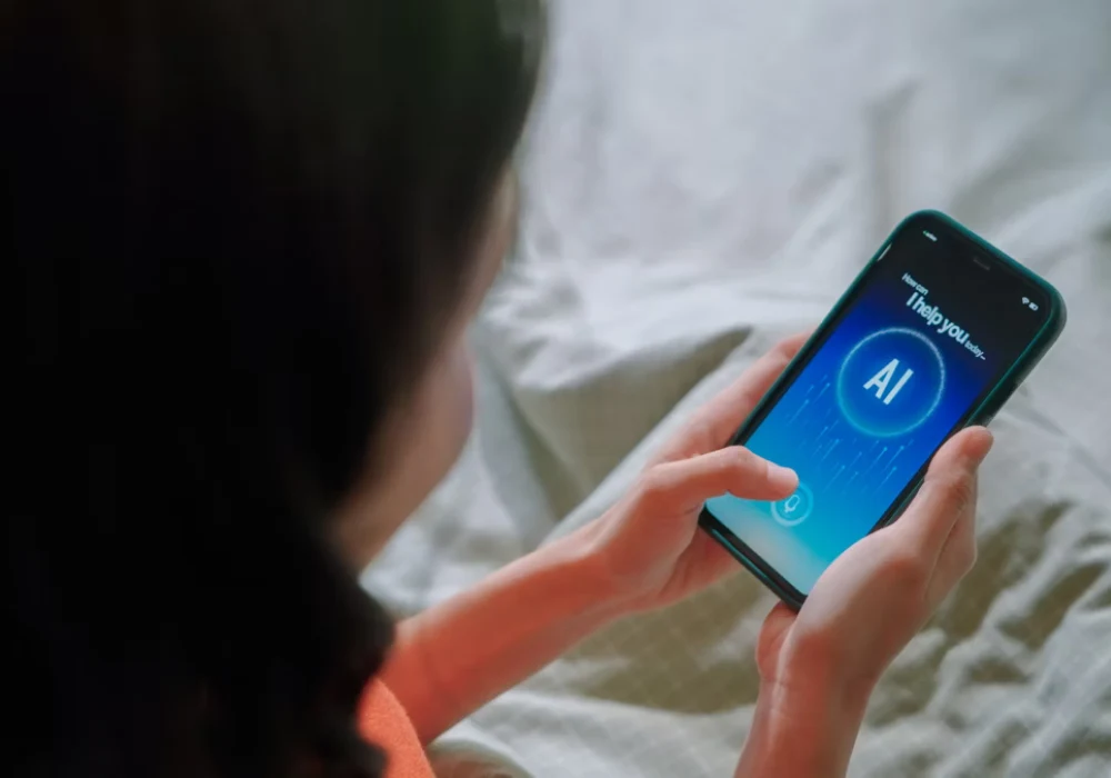 Person holding a smartphone displaying an AI assistant interface, symbolising artificial intelligence in everyday digital interaction.&nbsp;
