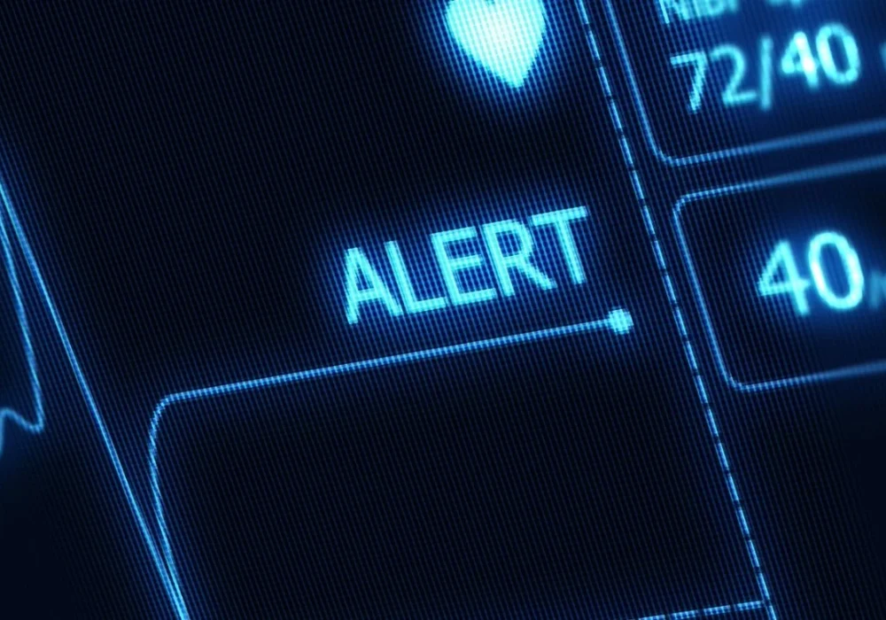 Patient monitor screen displaying&nbsp;an alert&nbsp;and vital signs.&nbsp;