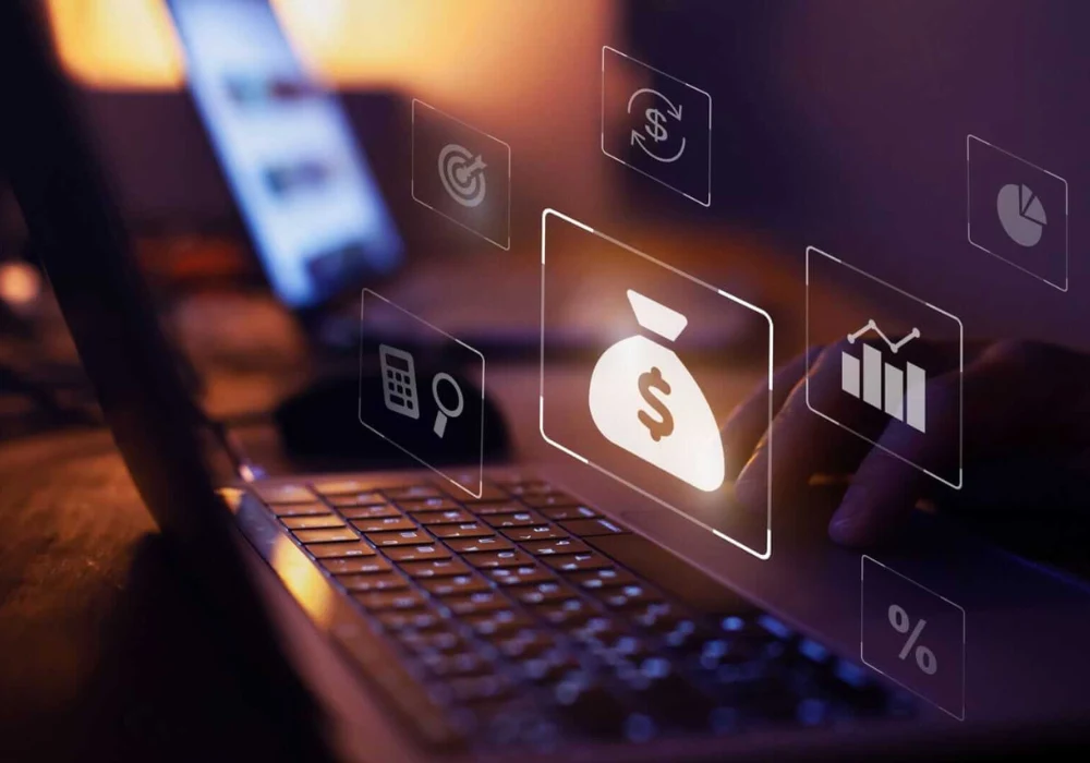 Close-up of a person working on a laptop with digital finance and analytics icons symbolizing financial planning, investment&nbsp;analysis&nbsp;and business growth.&nbsp;