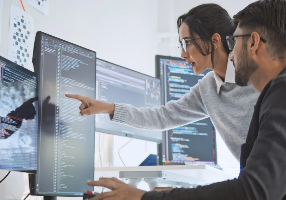 Developers collaborating on source code review in a software engineering or cybersecurity workspace&nbsp;