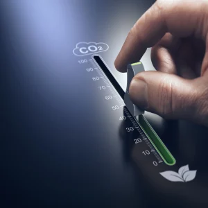 Hand adjusting a control knob to reduce CO₂ emissions,&nbsp;representing&nbsp;environmental sustainability, carbon footprint reduction, and green innovation efforts.&nbsp;