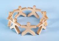 Wooden human figures arranged in a circle &ndash; unity, teamwork and community collaboration.&nbsp;