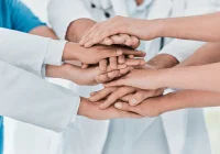 Stacked hands of diverse healthcare workers &ndash; unity, support, and collaboration in patient care.&nbsp;