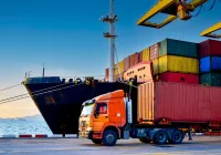 Cargo ship and freight truck at the port terminal during container loading operations&nbsp;
