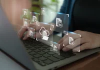  Hands typing on laptop with digital health records and cloud document icons, symbolising electronic medical data management, health information exchange and secure cloud storage in healthcare.&nbsp;