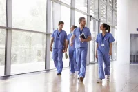 Medical team walking through hospital corridor during clinical rounds in modern healthcare facility