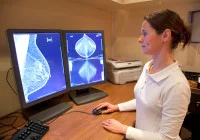 Radiologist reviewing mammogram images on dual monitors for breast cancer screening analysis&nbsp;