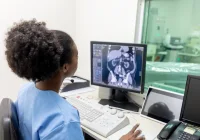 Radiology technician reviewing abdominal CT scan in control room.&nbsp;