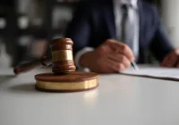 Judge with gavel signing legal documents symbolising law, justice and courtroom decisions.