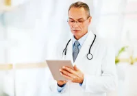 Senior doctor using a digital tablet for patient care management&nbsp;