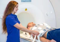 Radiology technologist preparing a male patient for MRI scan in modern hospital. 