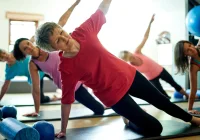 Senior women exercising in a group fitness class for strength and flexibility.&nbsp;