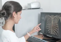 Radiologist reviewing CT images on a calibrated diagnostic monitor at a home teleradiology workstation.&nbsp;