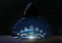 AI-powered cybercrime: hooded hacker using a laptop to target hospital data and network security.&nbsp;