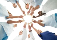 Healthcare team joining jigsaw pieces, symbolising hospital collaboration and sustainability strategy.&nbsp;