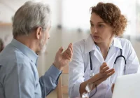  Clinician reviews a care plan with an older patient on a shared EHR, illustrating coordinated network care and real-time data sharing.&nbsp;