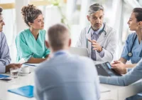 Medical and administrative professionals meeting in a hospital boardroom, representing collaborative healthcare leadership and strategic planning.&nbsp;
