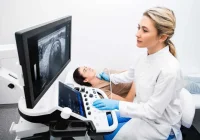 Female patient undergoing an abdominal ultrasound examination performed by a clinician using a modern ultrasound system to assess internal organs.&nbsp;