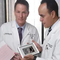 Cardiologists Dr. James de Lemos (left) and Dr. Amit Khera (right) review a printout from an EKG and a calcium scan, two of five tests they demonstrated could improve risk assessment for heart disease.