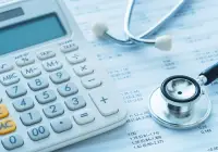 Healthcare cost analysis concept with stethoscope, calculator and financial data sheets