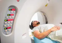 Male patient undergoing CT scan lying inside computed tomography scanner in hospital&nbsp;