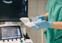 Healthcare professional cleaning an ultrasound probe in a clinical setting, illustrating hygiene and infection control in medical imaging.&nbsp;